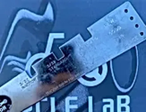 サイクルラボのロゴの上に置かれた金属製のチェーンチェッカーの写真